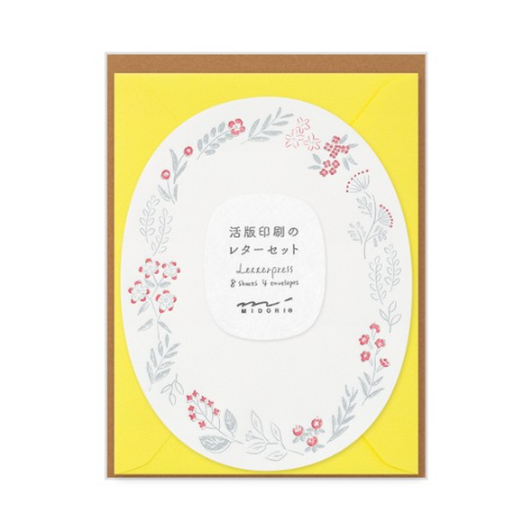 Oval sheet with 2-color border of gray and red flowers and leaves with a yellow envelope.