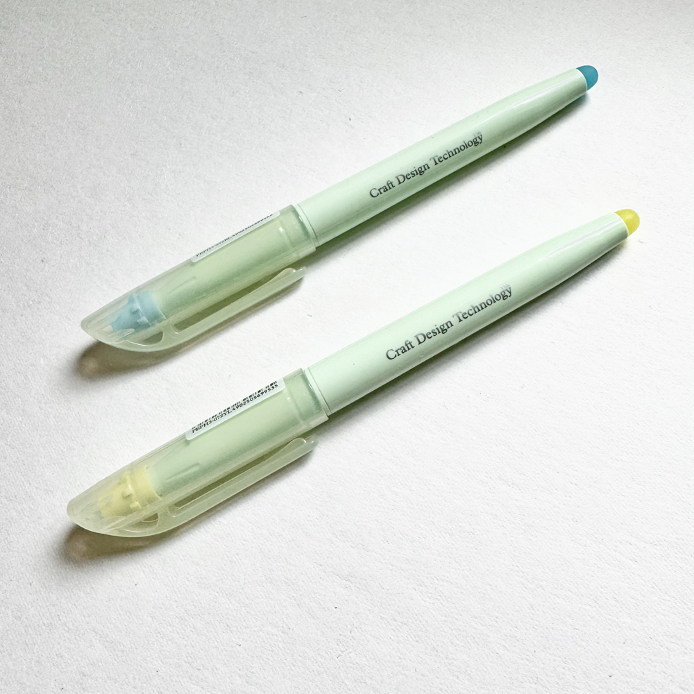 Two light green pens with clear caps