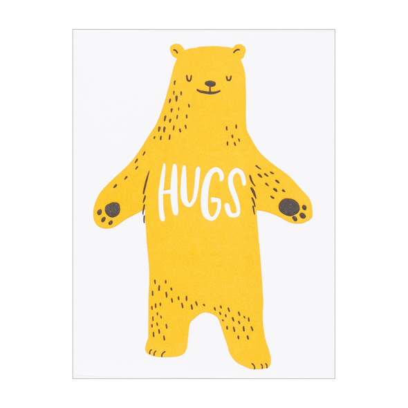 yellow bear with eyes closed and open arms with HUGS written on its chest