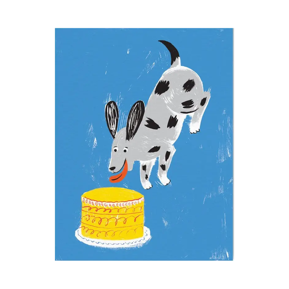Blue background with an excited dog about to pounce on a yellow cake.