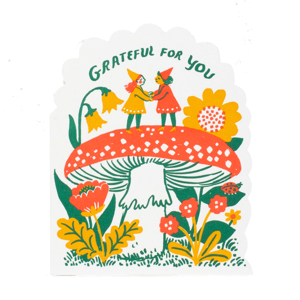 Curvy die-cut card with 2 gnomes holding hands on top of a mushroom under the text GRATEFUL FOR YOU.